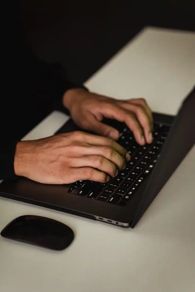 crop unrecognizable man typing on laptop keyboard