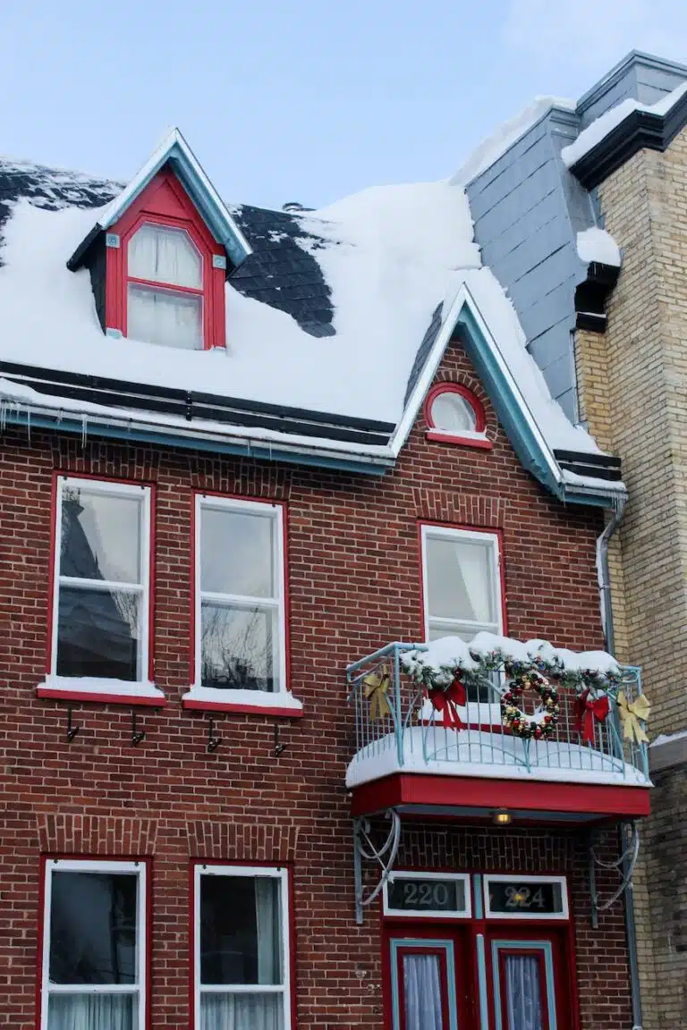 a snow covered roof of a brick house