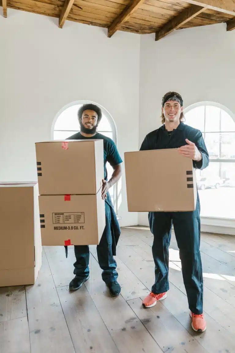 two men standing carrying cardboard boxes