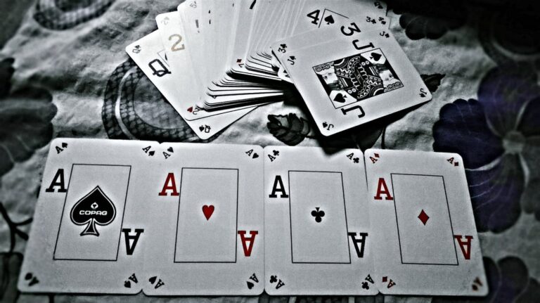 grayscale photography of playing cards placed on cloth