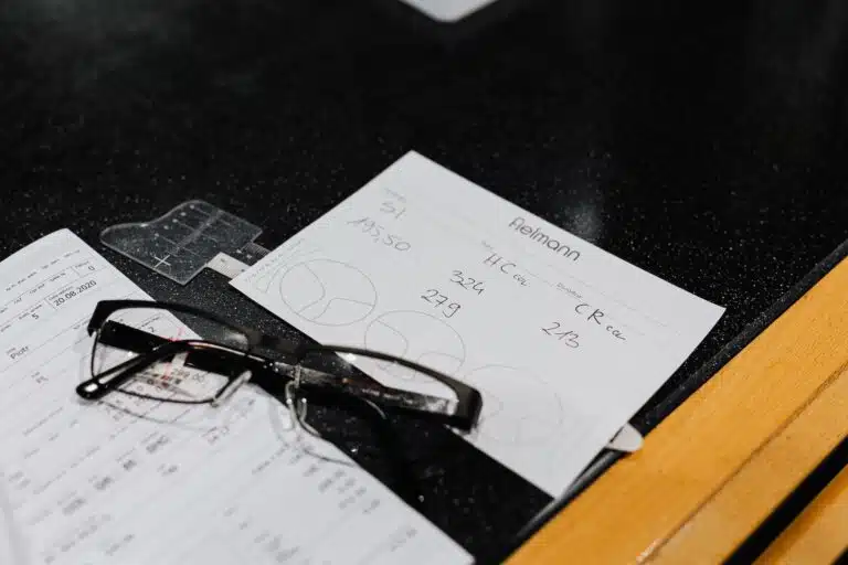 medical prescription beside the eyeglasses on a black surface