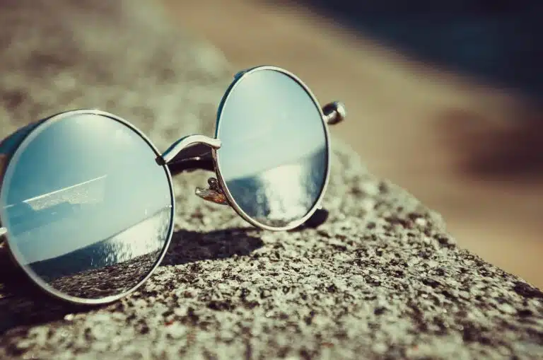 silver framed hippie sunglasses on concrete