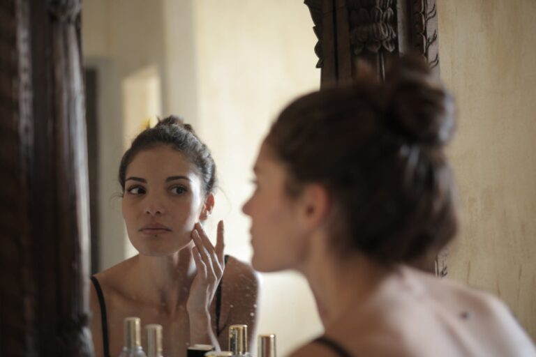 reflection photo of woman touching her cheek